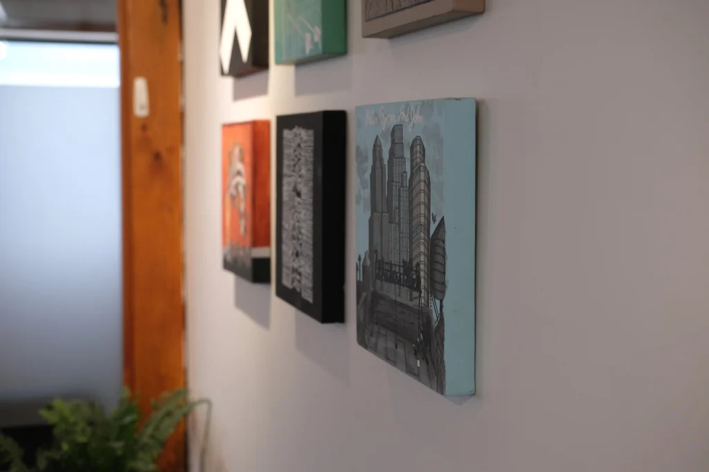 Wall art display at Hope Media House gallery with various colorful paintings.