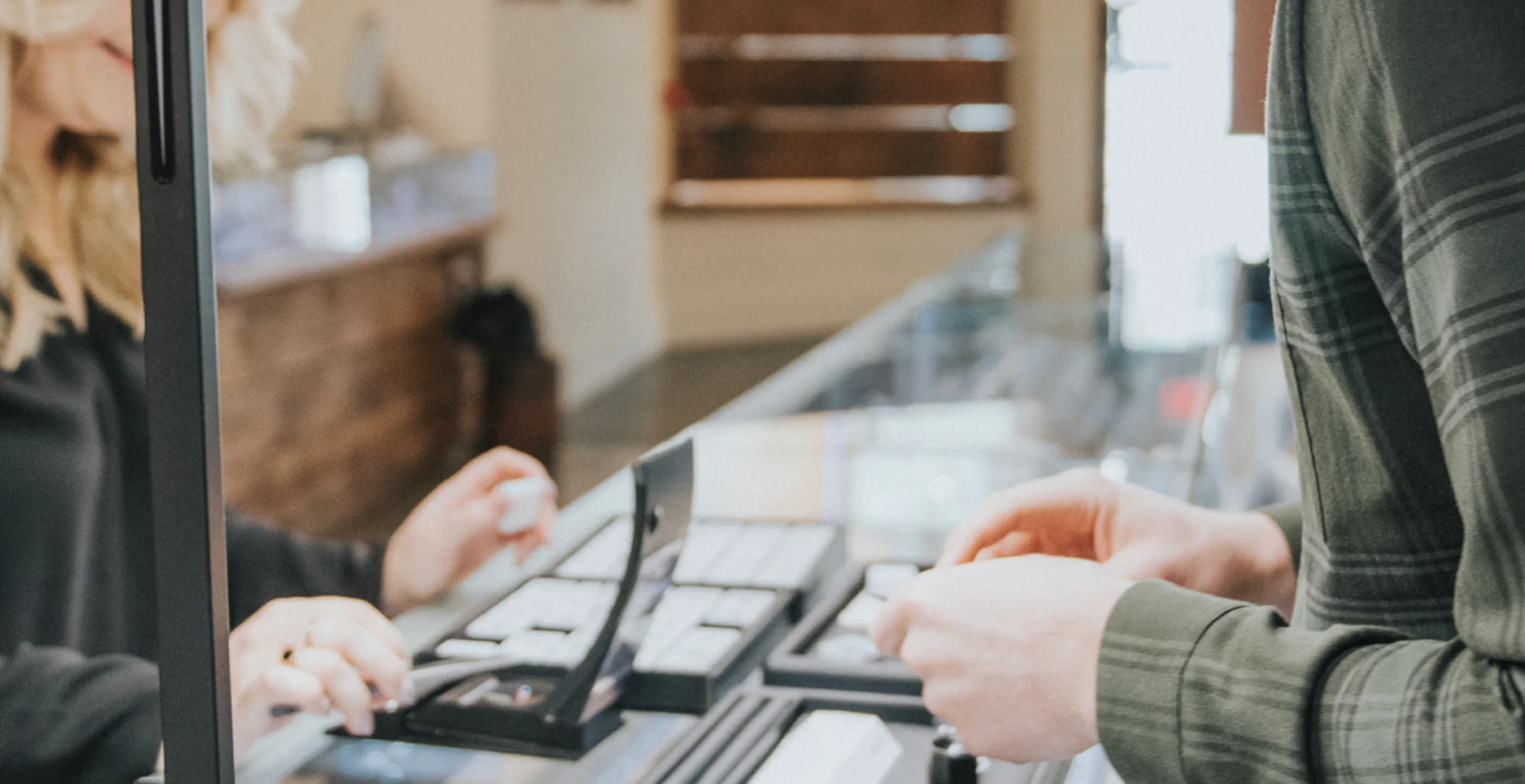 It looks like the image shows a jewelry store setting, with one person interacting with another at a display case. If you need specific information or a description, feel free to ask!